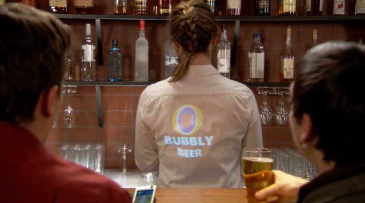 Guys at bar with pico projector projecting video on bartender