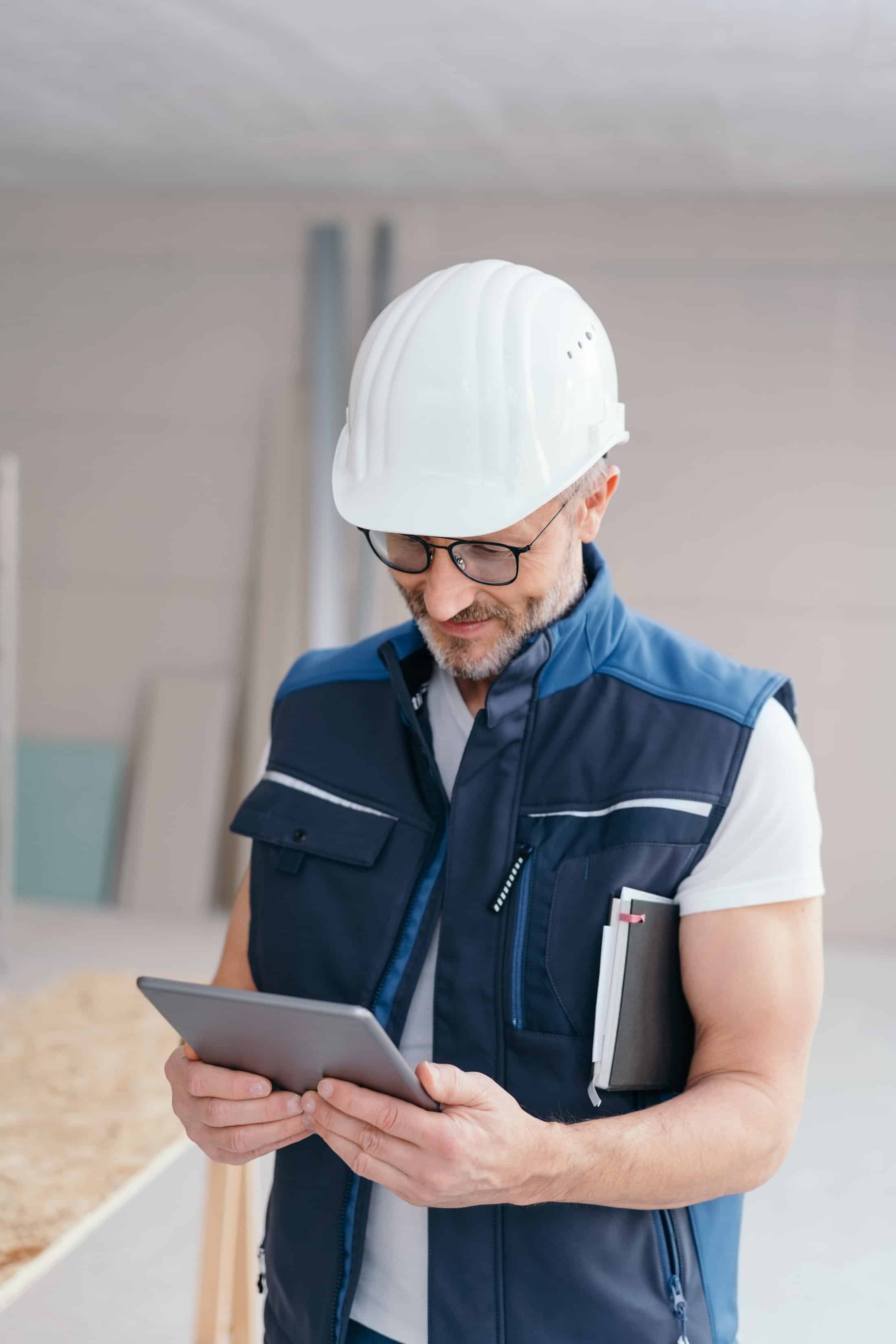 Engineer visiting job site and reviewing specification on the tablet computer.